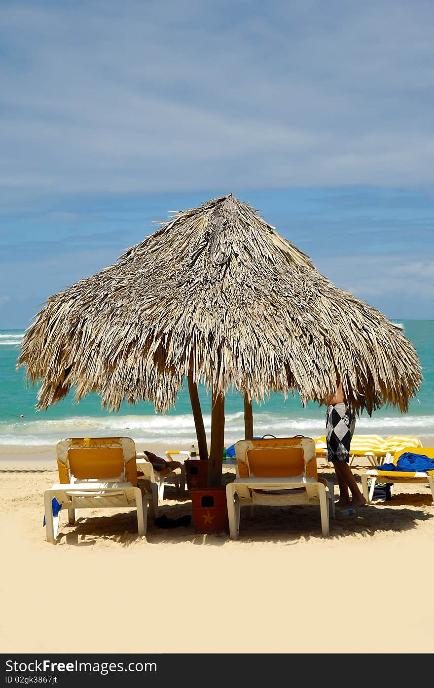 Parasol made out of palm leafs on exotic beach.