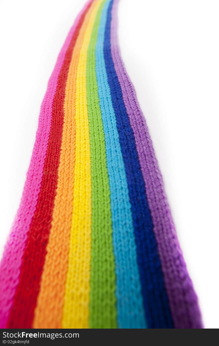 The image of a bright rainbow knitted scarf