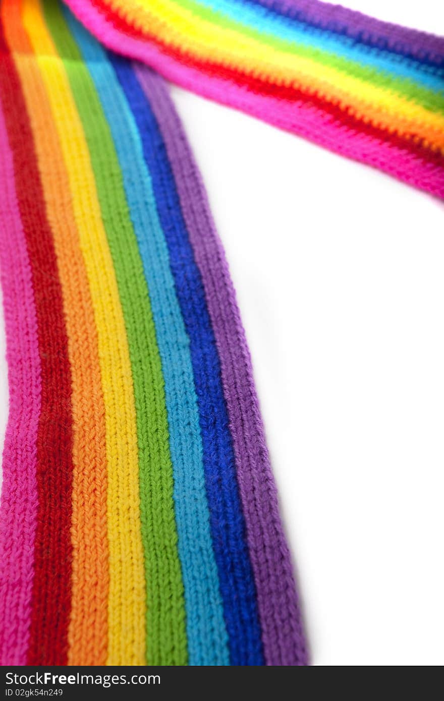 The image of a bright rainbow knitted scarf