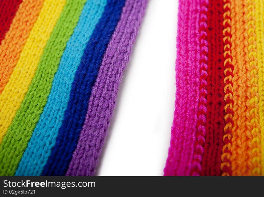 The image of a bright rainbow knitted scarf