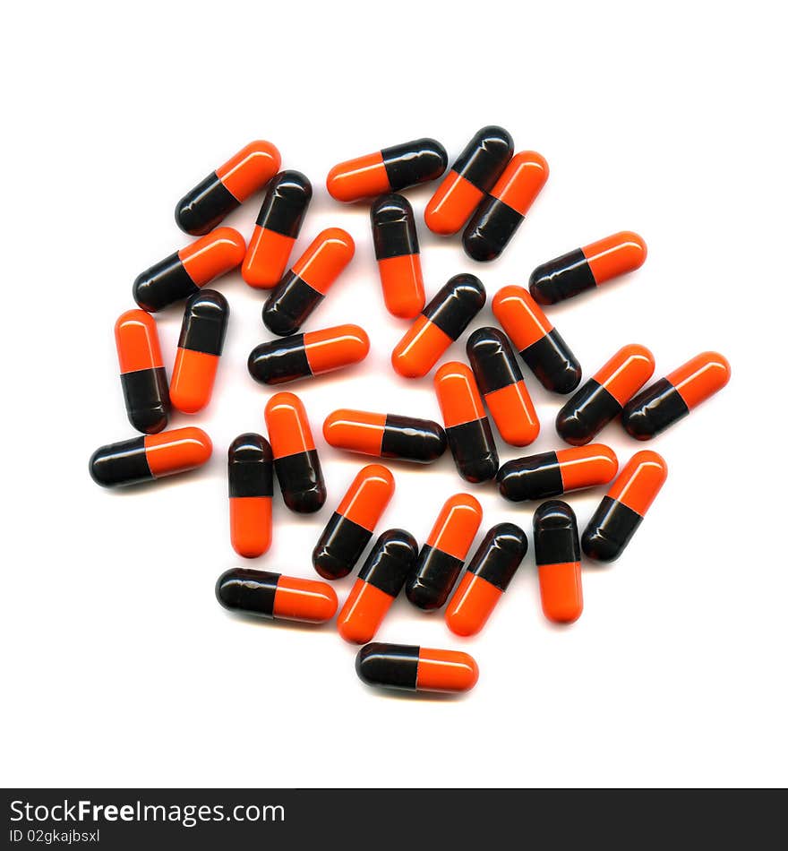 Red and black pills scattered over white background. Red and black pills scattered over white background