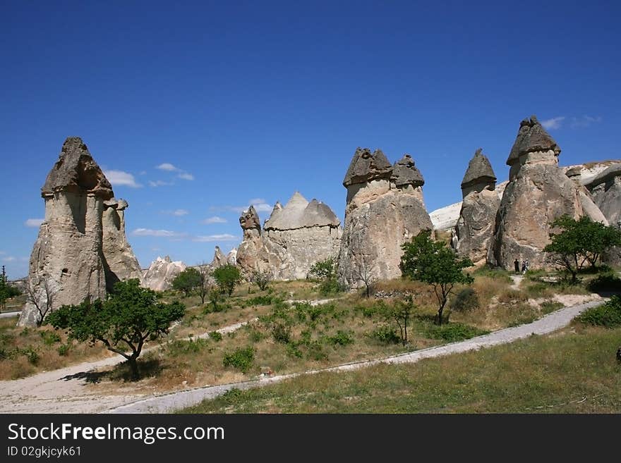 Hatted fairy chimneys against blue sky.