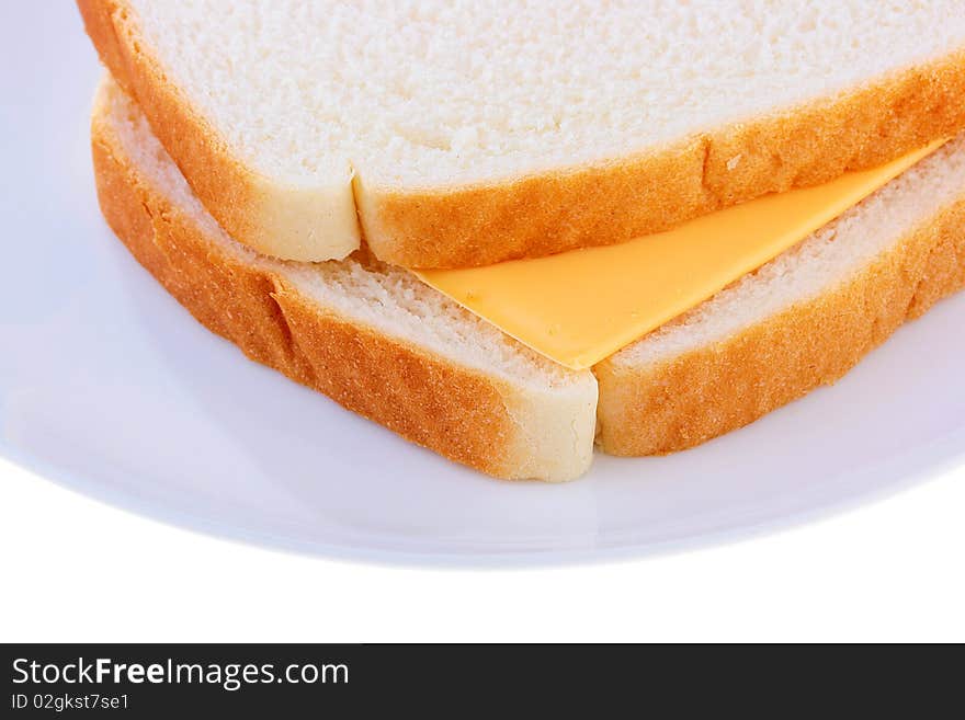 On a plate two slices of bread, between them cheese.