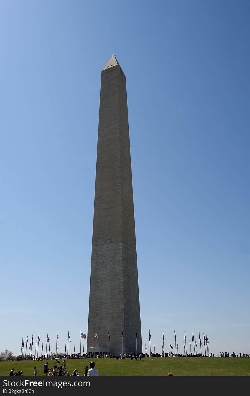 Washington monument on sunny day with flags