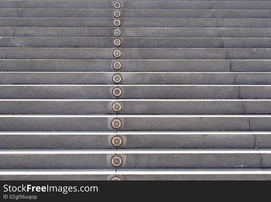 A gray color step with lamp, as part of a modern building.