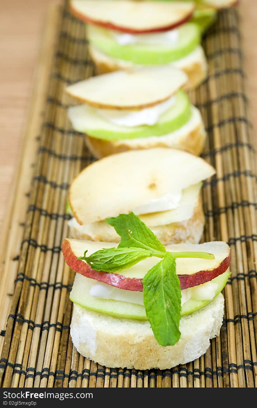 Canapes row, melting brie cheese and fresh organic fruits. Canapes row, melting brie cheese and fresh organic fruits