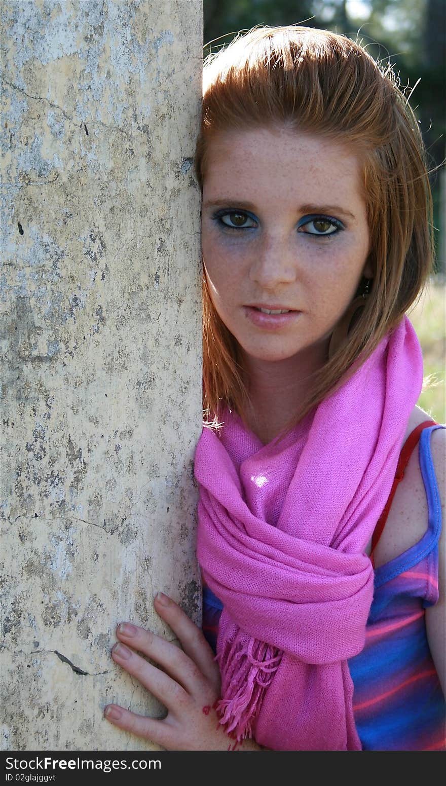 A beautiful woman leaning on a pillar