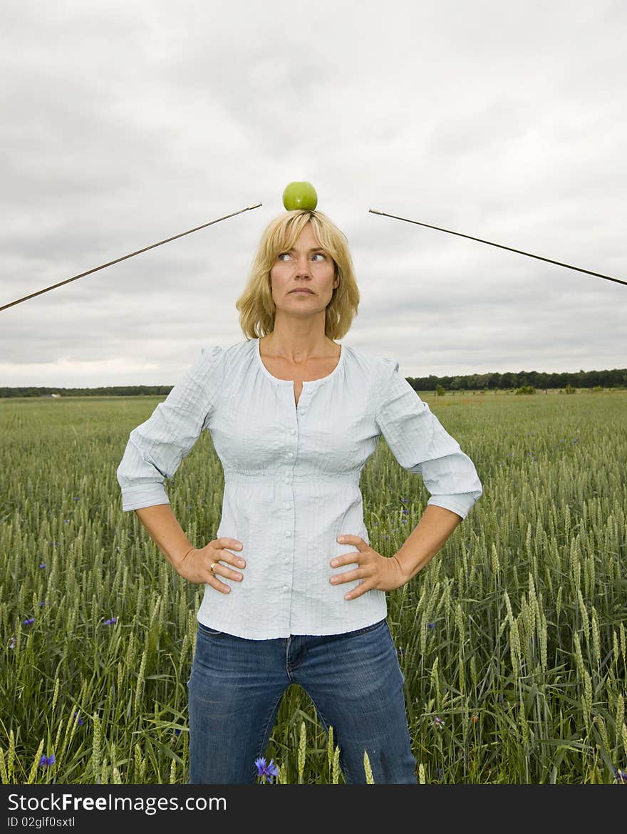 Woman as Wilhelm Tell in a field between two duelling people. Woman as Wilhelm Tell in a field between two duelling people.