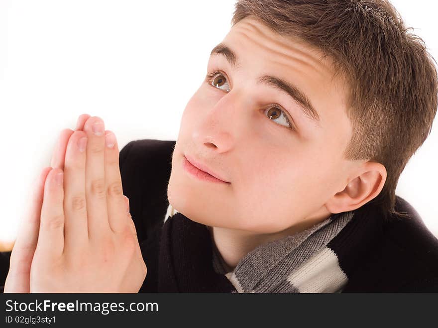 Handsome young man praying on a white background