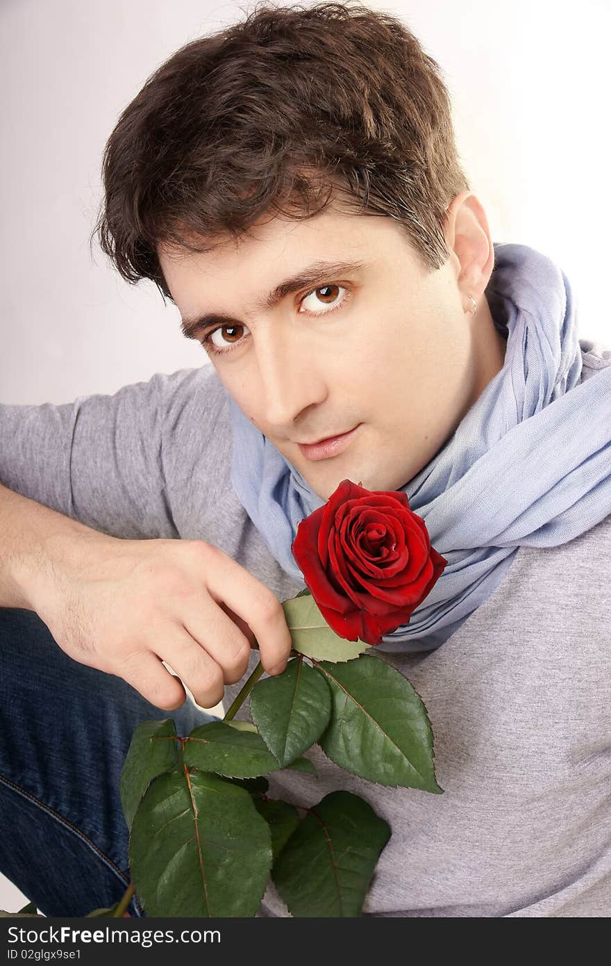 Young attractive smiling man with red rose, studio shot. Young attractive smiling man with red rose, studio shot