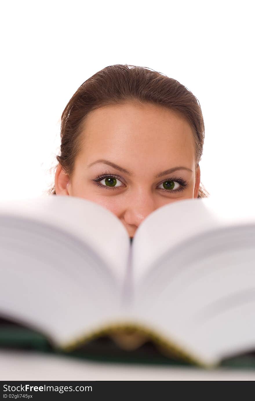 Pretty girl sitting at a table with a book on white background. Pretty girl sitting at a table with a book on white background