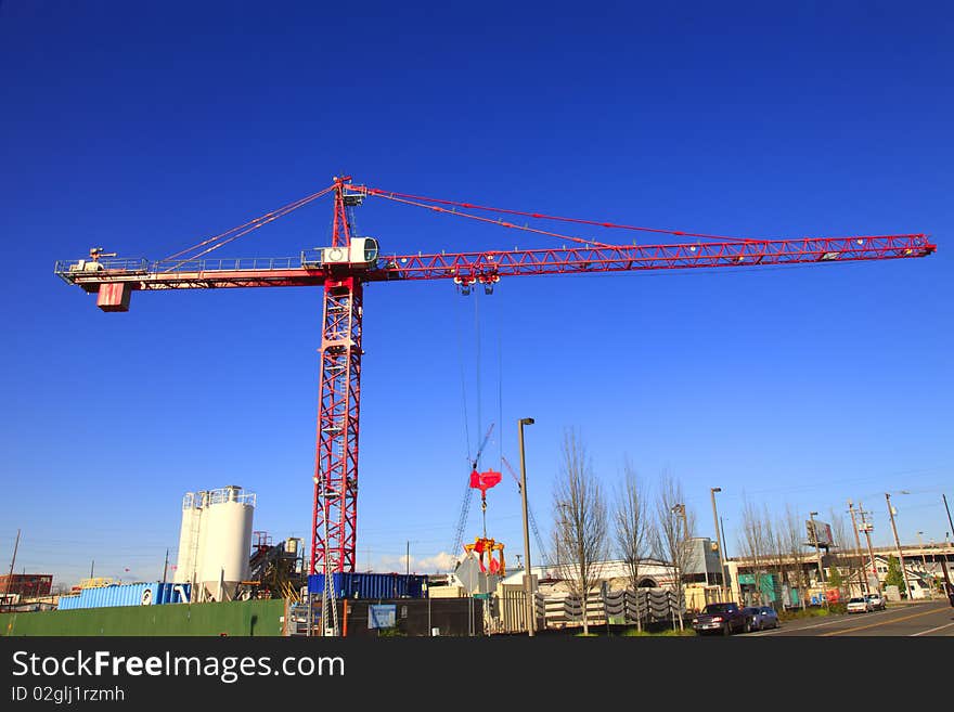 A large crane moving equipment around in the construction yard. A large crane moving equipment around in the construction yard.