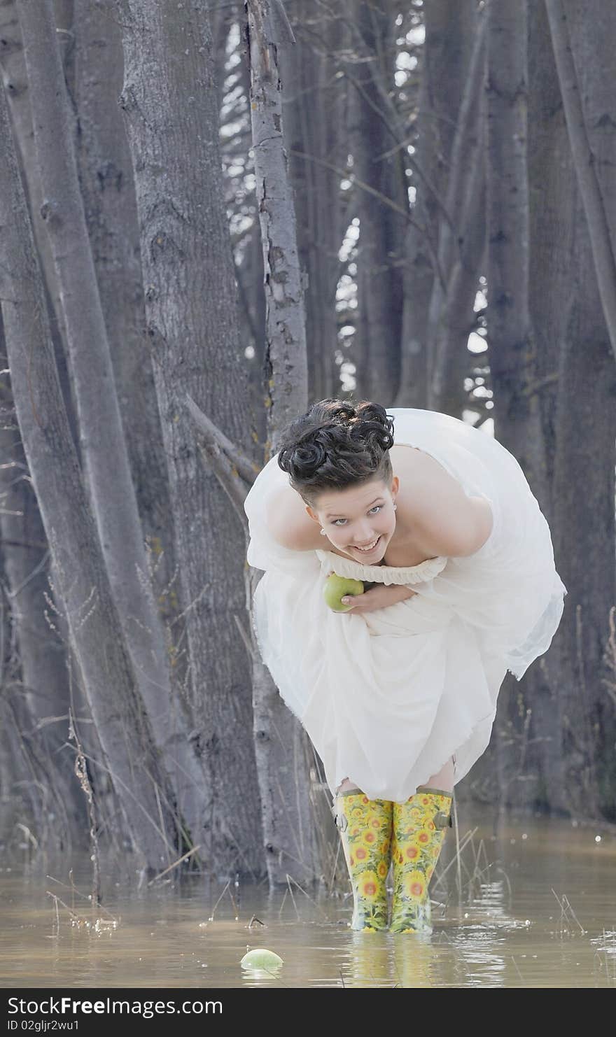 Funny bride with apples in the river