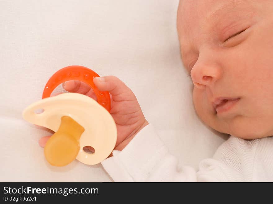 Beautiful baby sleeps next to the nipple