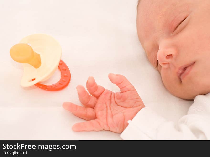 Nice baby sleeps next to the nipple