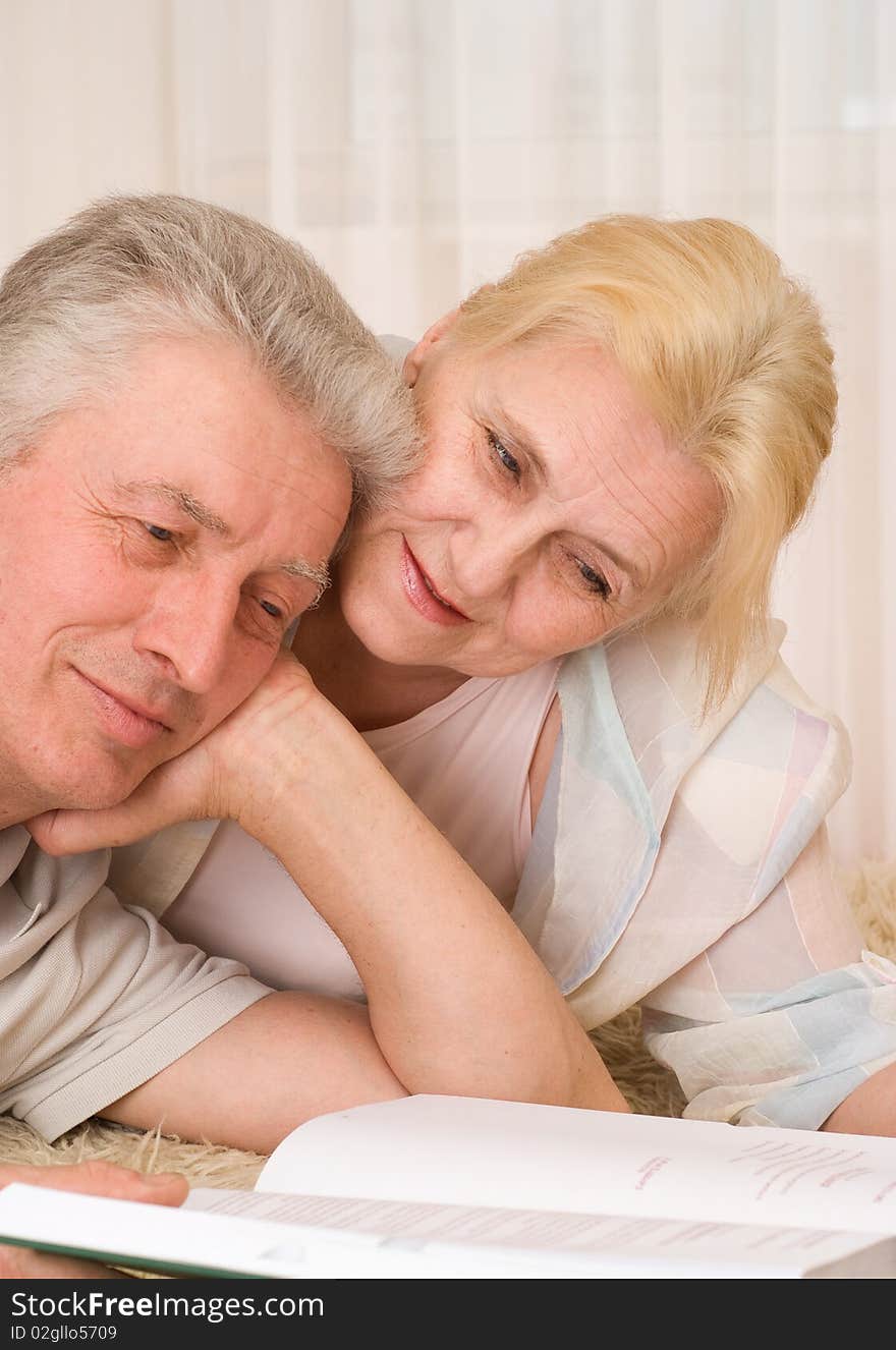 Smiling elderly couple with a book