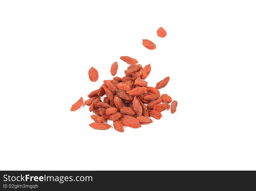 Pile of red dry goji berries on a reflective white background