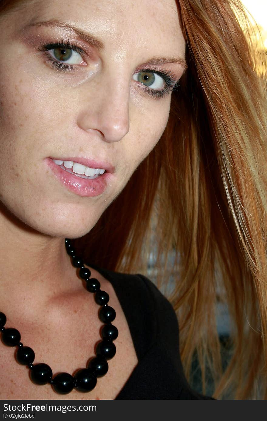 A close up of a woman with black pearls