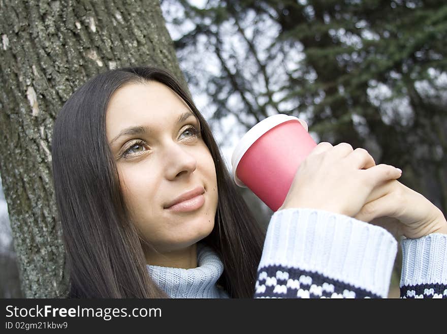 Female in a park drinking coffee