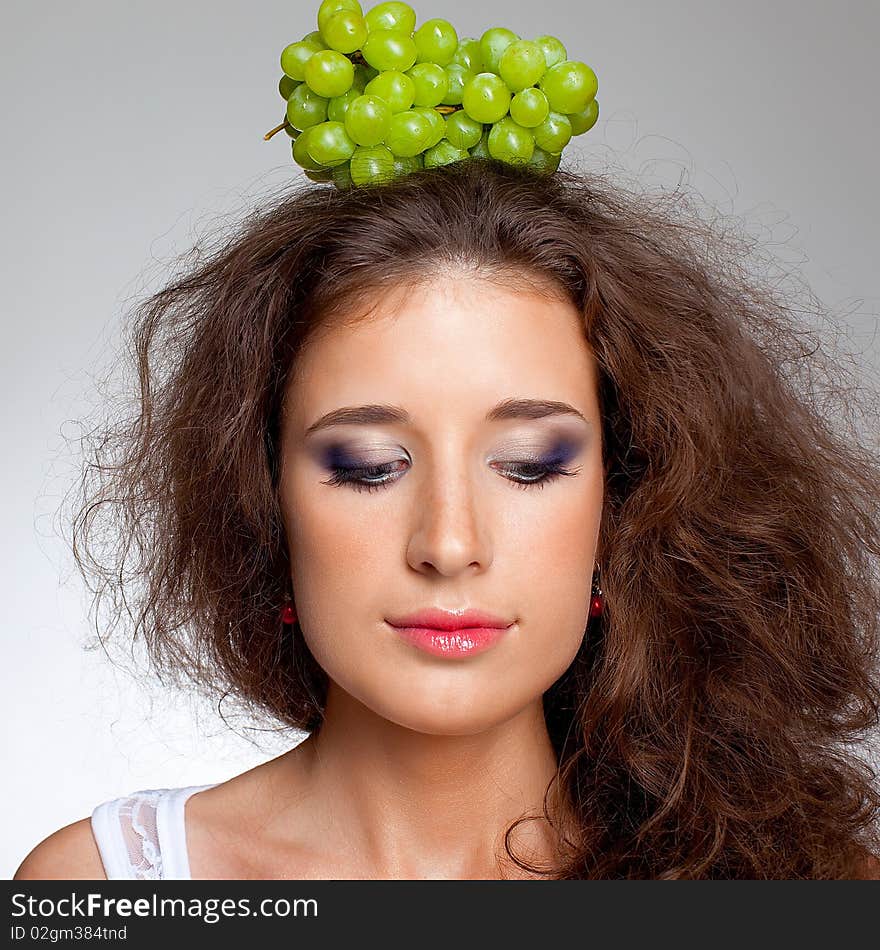 Beautiful girl with brown curly hair and grapes. Beautiful girl with brown curly hair and grapes