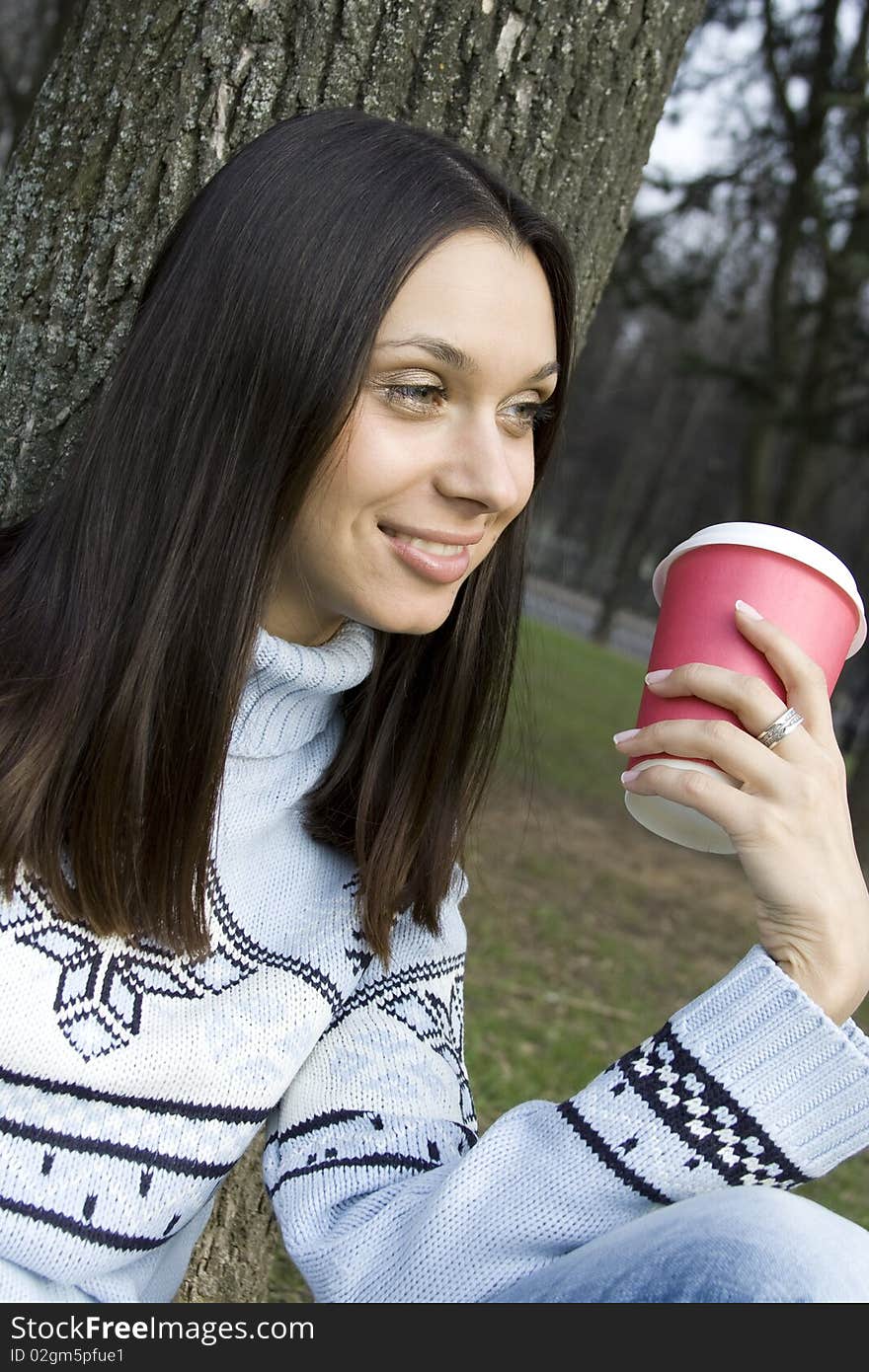 Beautiful girl sunny day in the park drinking coffee from paper cups. Portrait. Beautiful girl sunny day in the park drinking coffee from paper cups. Portrait