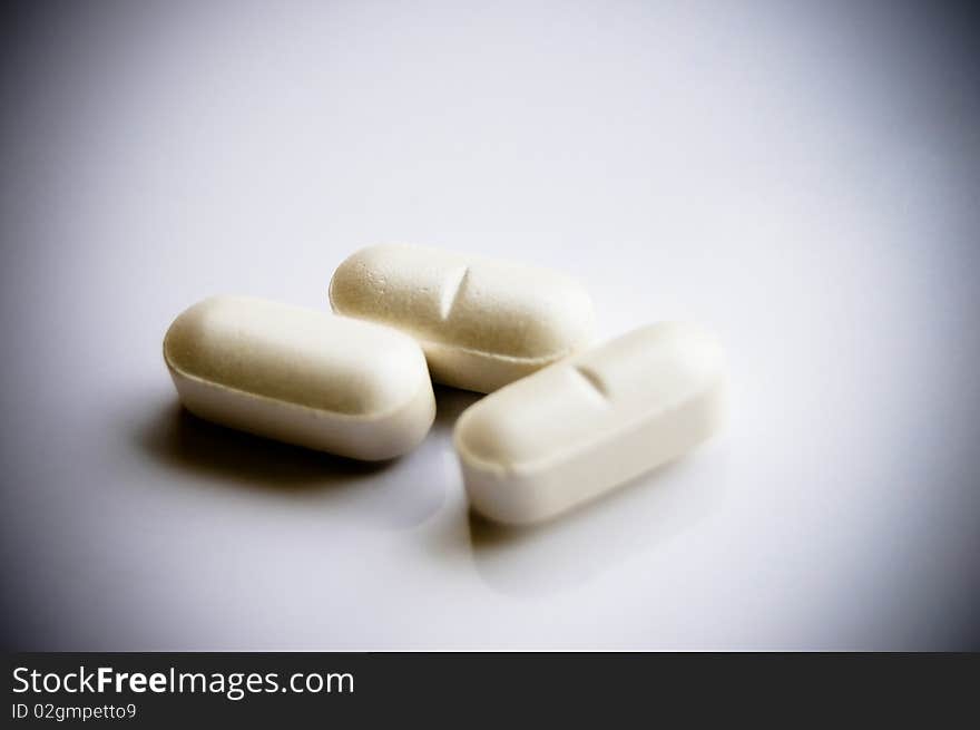 Close up picture of vitamin pills on white background