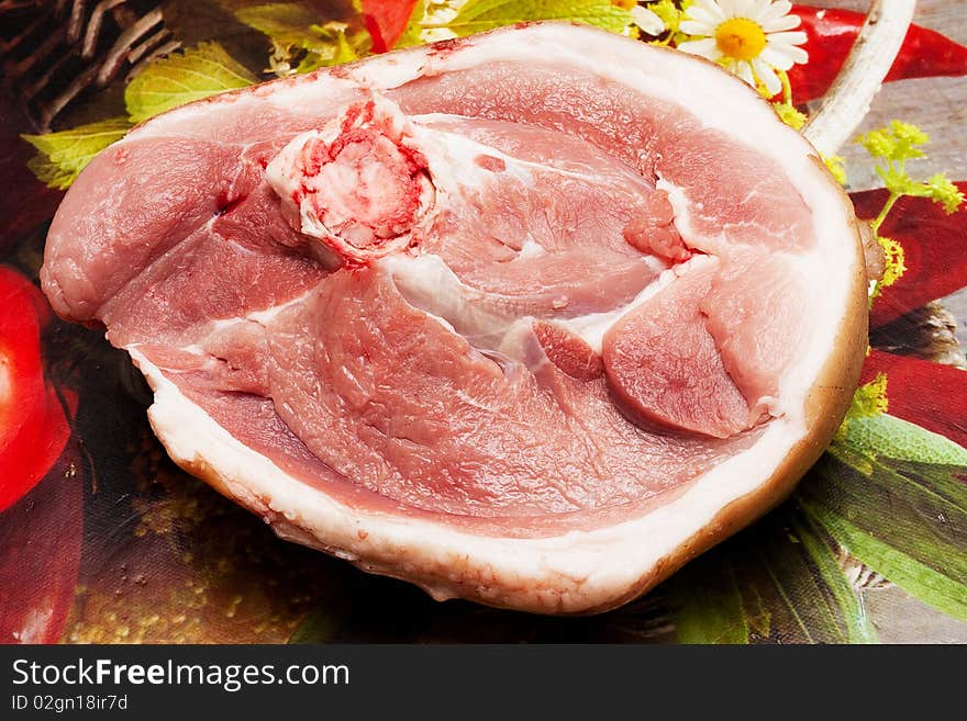 A piece of raw meat at a plural background. A piece of raw meat at a plural background