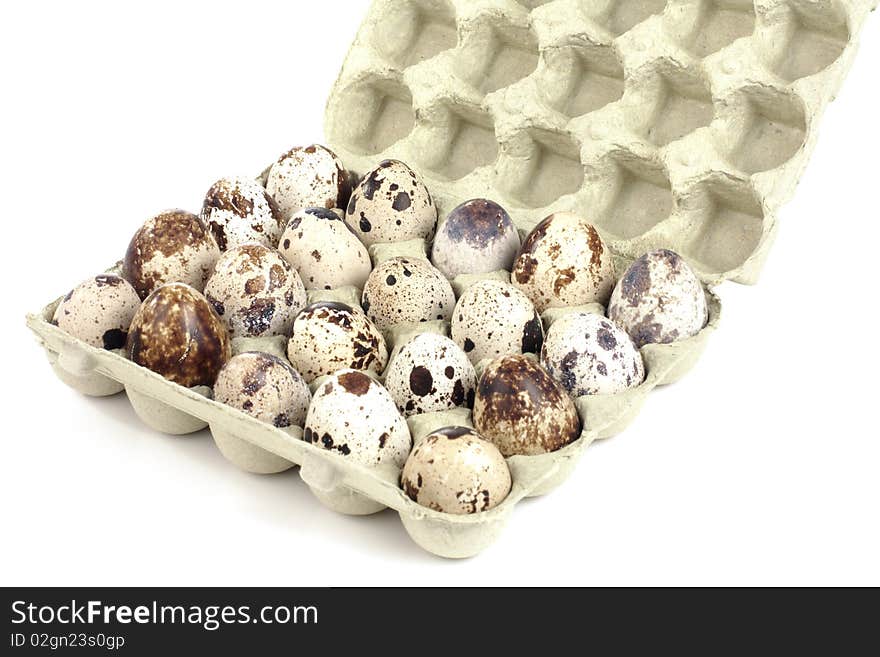 Quail eggs in a box on a white background