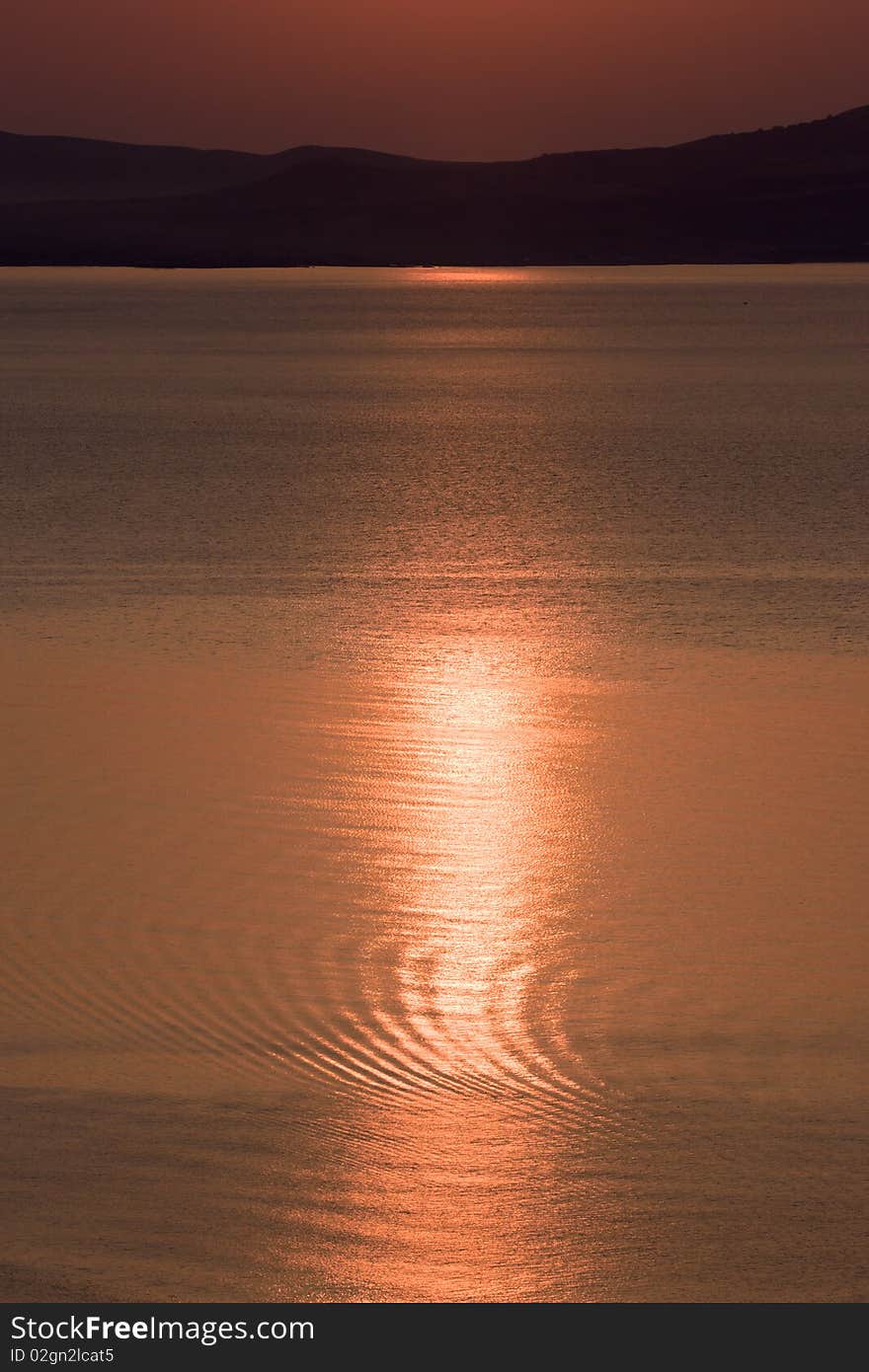 Morning on sea coast, red sun is reflected in water. Morning on sea coast, red sun is reflected in water