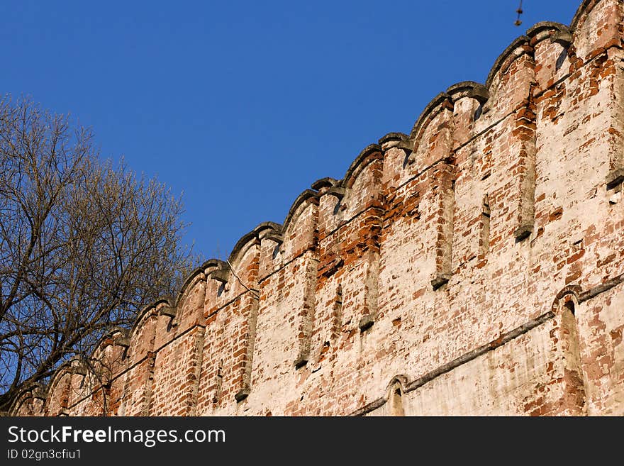 Old castle brick wall on blue sky. Old castle brick wall on blue sky