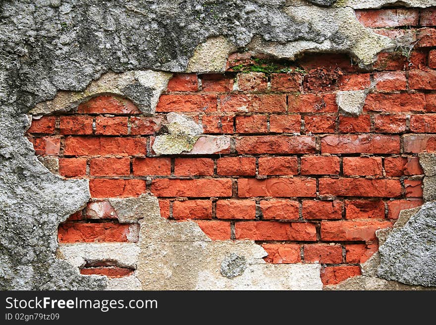 Part of a red brick wall framed by old plaster crumbled away. Part of a red brick wall framed by old plaster crumbled away.