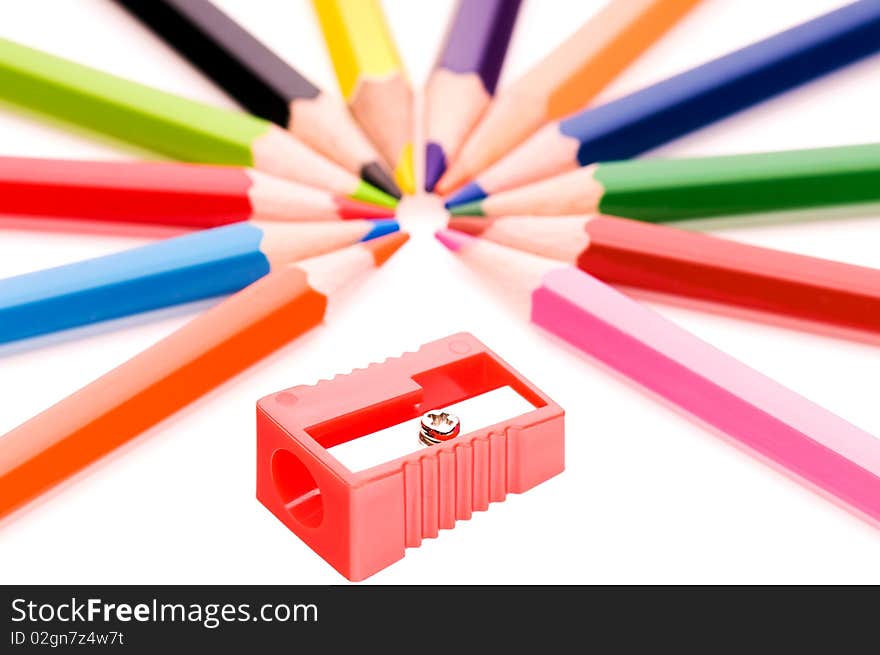 Close-up image of multicolor pencils and red sharpener isolated on white background