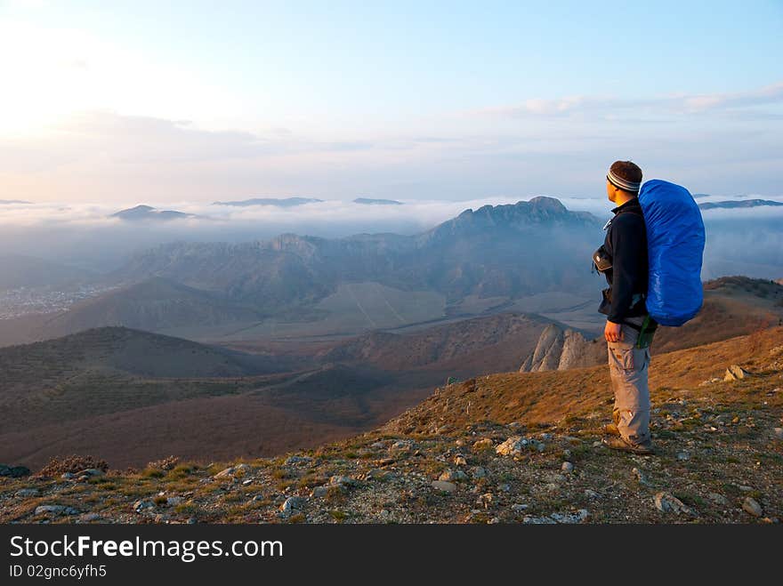 Hiker on a peak enjoys mountain landscape