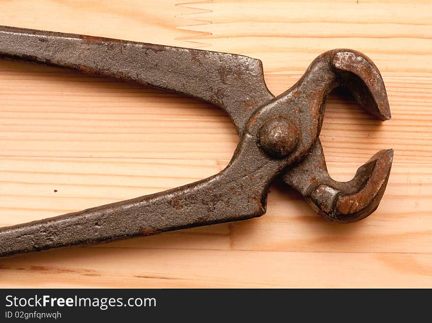 Old tongs on wooden texture