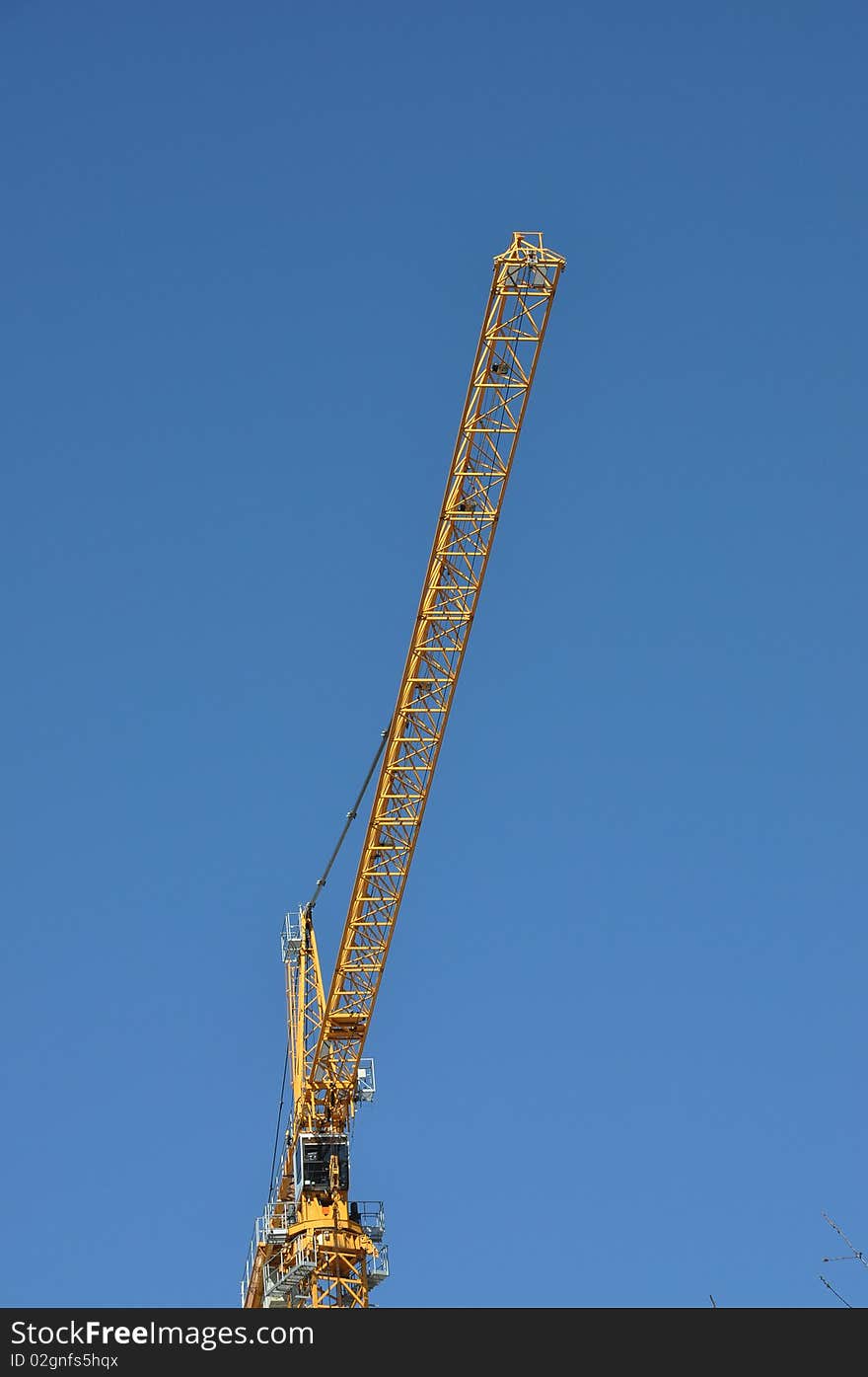 Yellow crane against blue sky.