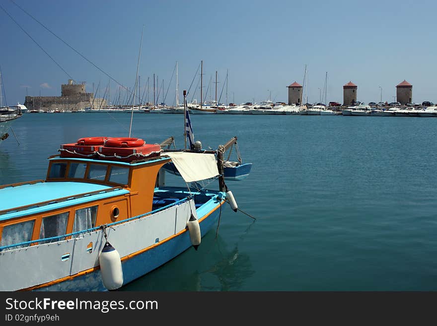 View to the harbour with the fortress and windmills in Rhodes in Greece