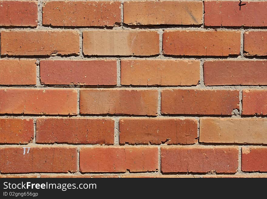 A reddish and orange colored brick wall. A reddish and orange colored brick wall