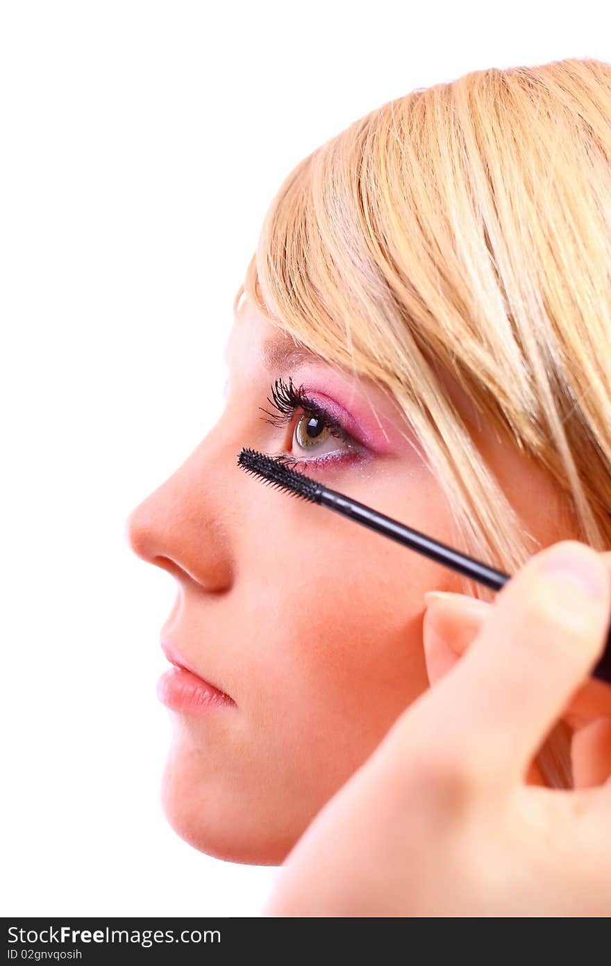 Pretty woman applying make up on a white background. Pretty woman applying make up on a white background