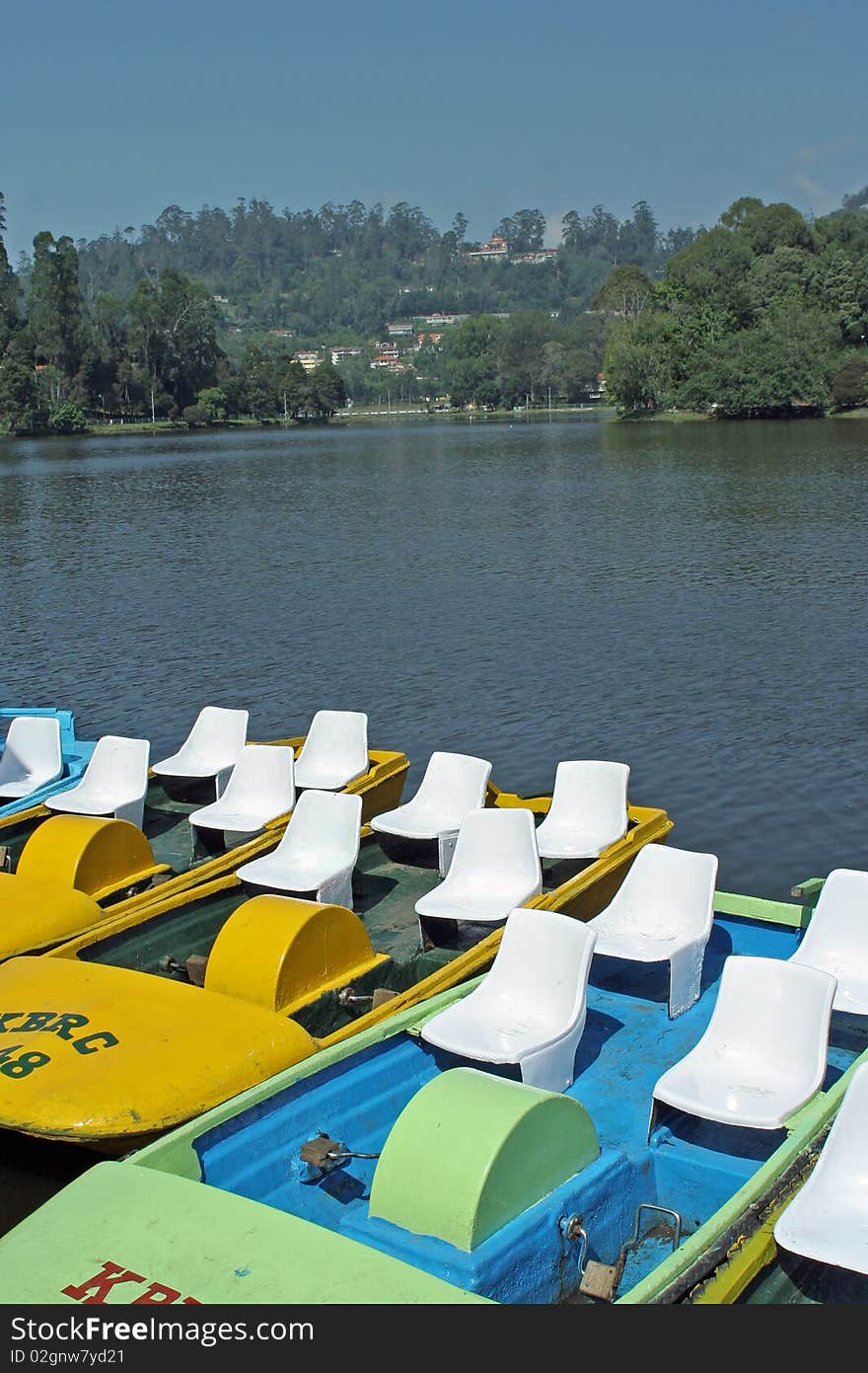 Yellow and green catamarans on the lake. Park around. Yellow and green catamarans on the lake. Park around.