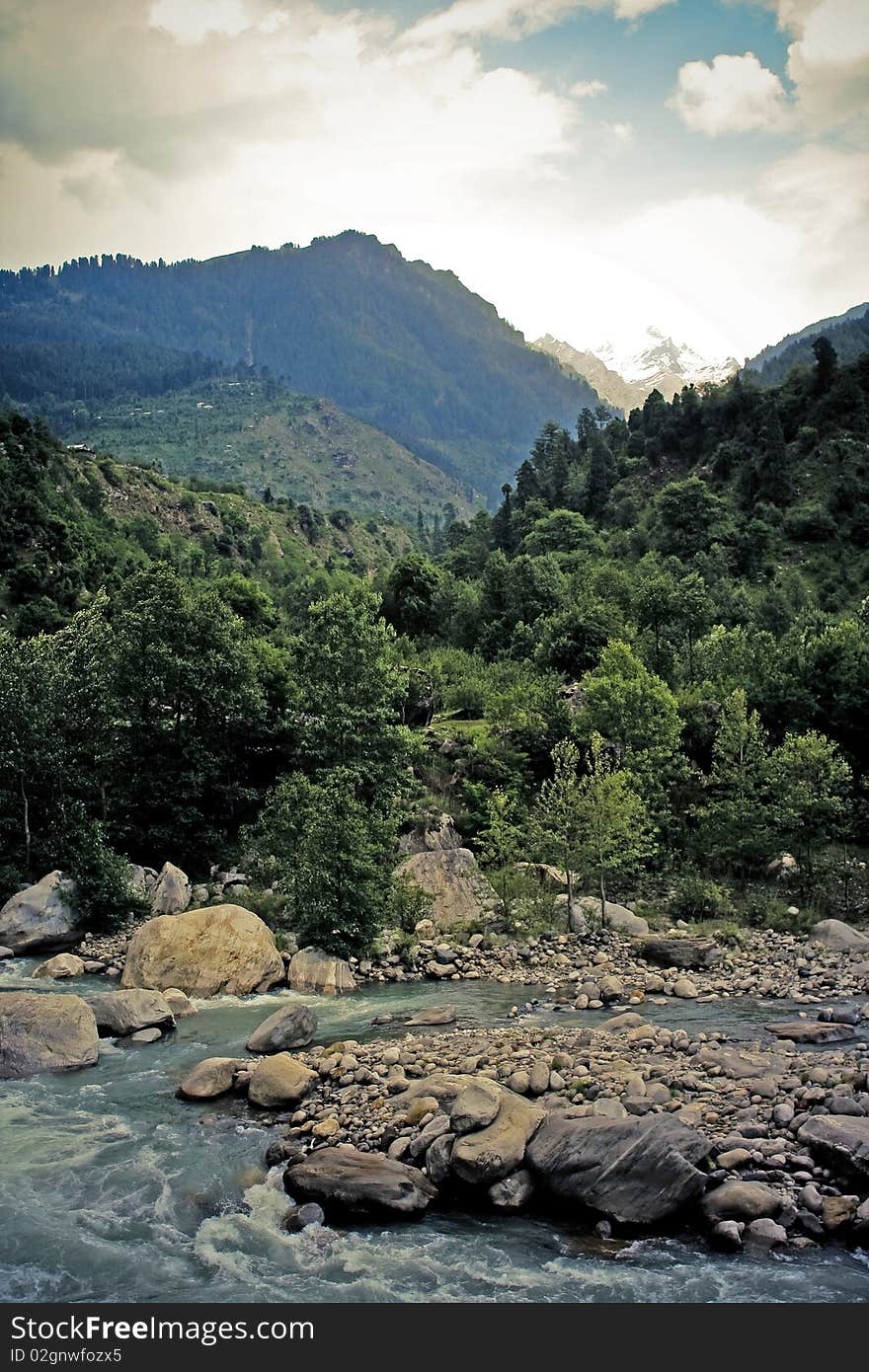 Cold fast mountain river in Kashmir, India. Mountain range on background. Cold fast mountain river in Kashmir, India. Mountain range on background.