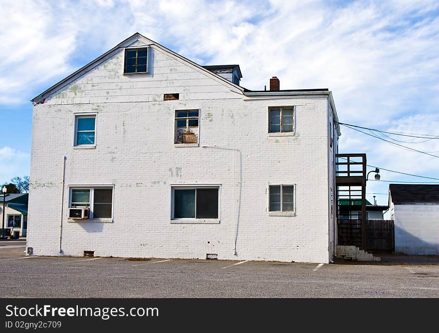 White colored building of apartments sits in a downtown area of a city. White colored building of apartments sits in a downtown area of a city.