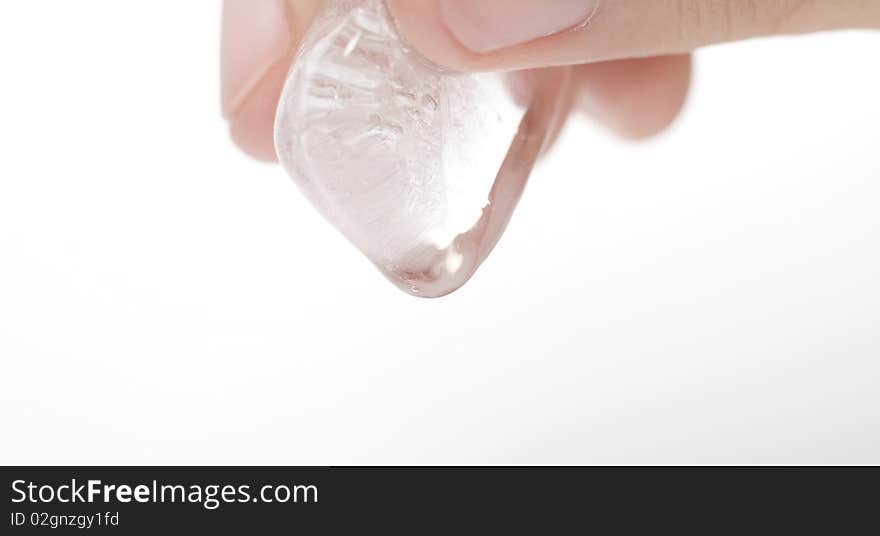 A person holding a clear ice cube which is melting. A person holding a clear ice cube which is melting.