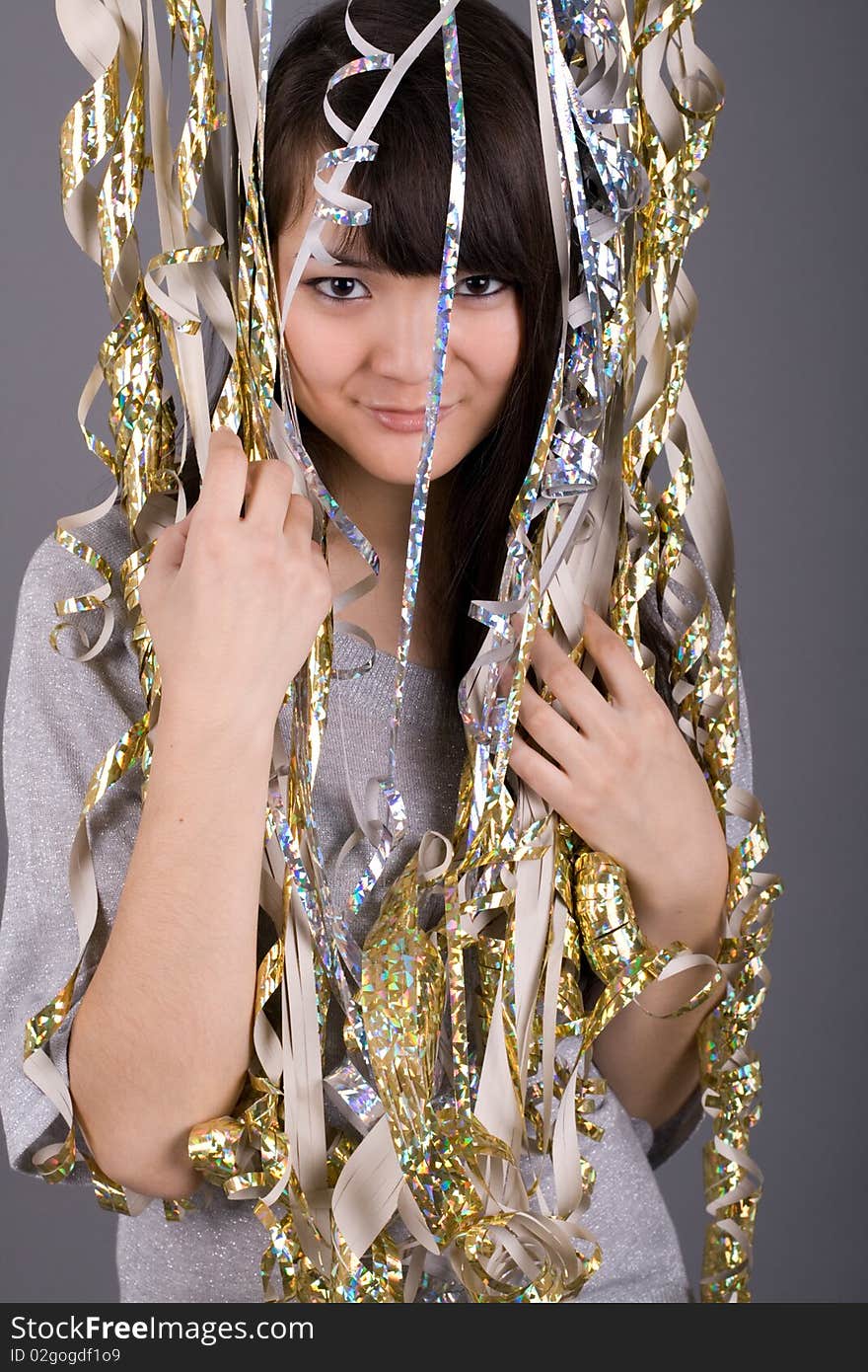 Girl standing among tinsel in studio