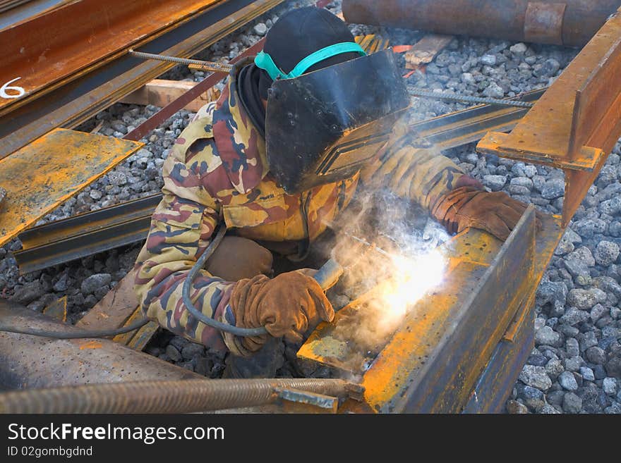 Welder in protective mask welding metal construction on open air. Welder in protective mask welding metal construction on open air