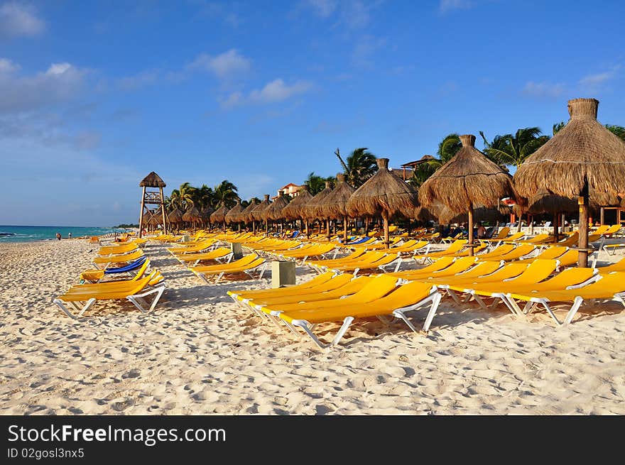 Sand, empty yellow plank beds, grassy umbrellas and the sea. Sand, empty yellow plank beds, grassy umbrellas and the sea.