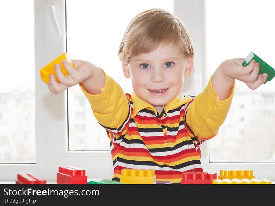 The beautiful little boy poses on a light background. The beautiful little boy poses on a light background