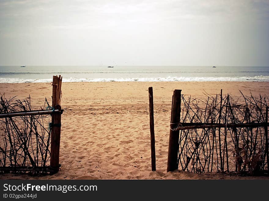 Wooden gate to the sea. Clear beach and still sea.