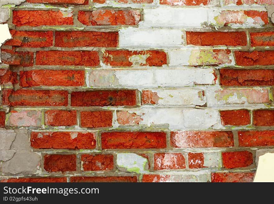 Old crumbling brick wall, with plaster chipping