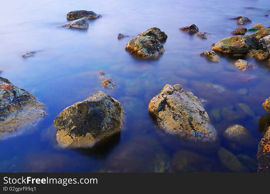 Sea stone in calm sea water. Sea stone in calm sea water