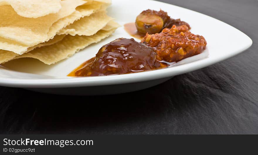 Traditional indian hors d'oeuvres of popadom and spicy pickles. Traditional indian hors d'oeuvres of popadom and spicy pickles.